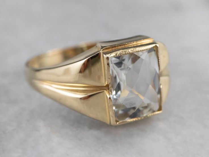 This Retro Era ring is full of refined sophistication! The white topaz at the center is pineapple cut for maximum sparkle and shine. Sleek shoulders and subtle milgrain on the bezel setting are particularly nice details! Metal: 10K Yellow Gold Gem: White Topaz approximately 4.00 Carats Gem Measurements: 7.9 x 9.8 mm, Rectangle Pineapple Cut Ring Size: 10.25 Marks: "10K" Stamped on the inside band Elegant White Signet Ring For Formal Occasions, Formal Baguette Cut Diamond Topaz Ring, Classic White Signet Ring With Center Stone, White Formal Signet Ring In Fine Jewelry Style, Formal Yellow Gold Topaz Ring With Diamond Cut, Formal Fine Jewelry Signet Ring With Rose Cut Diamonds, Formal Signet Ring With Rose Cut Diamonds, Classic Emerald Cut Topaz Ring With Prong Setting, Classic Cushion Cut Topaz Ring With Diamond