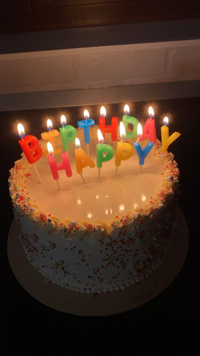 a birthday cake with lit candles on it