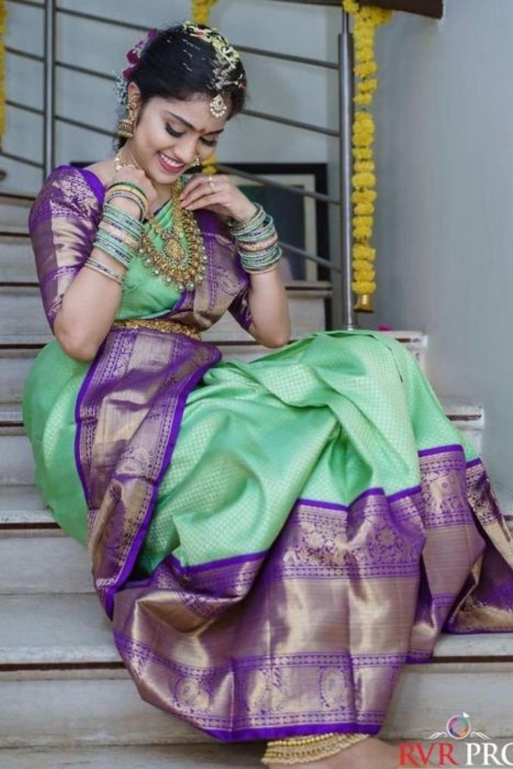 a woman in a green and purple dress sitting on steps