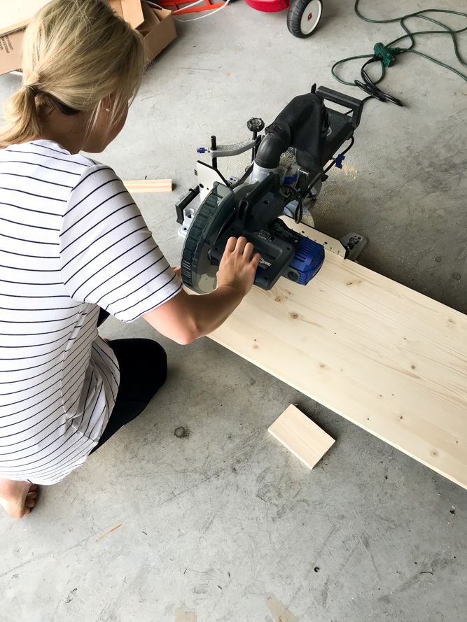 a woman working on a piece of wood with a planer in front of her