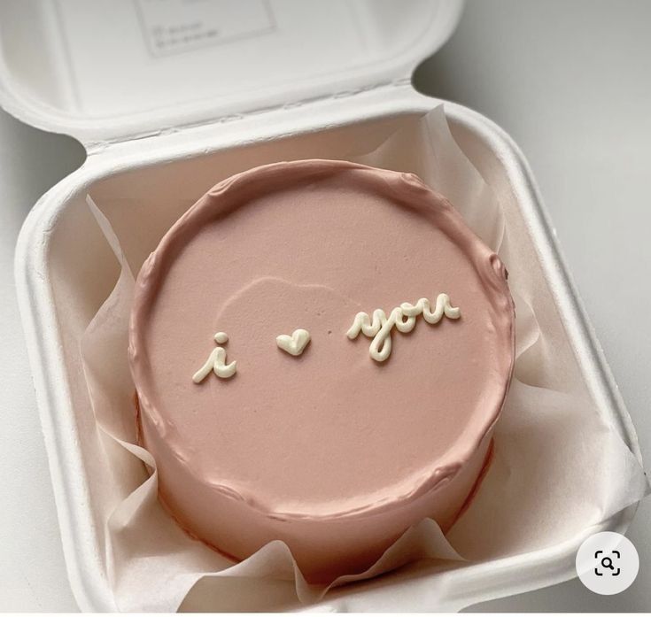 a pink cake in a white box with the word i love you written on it