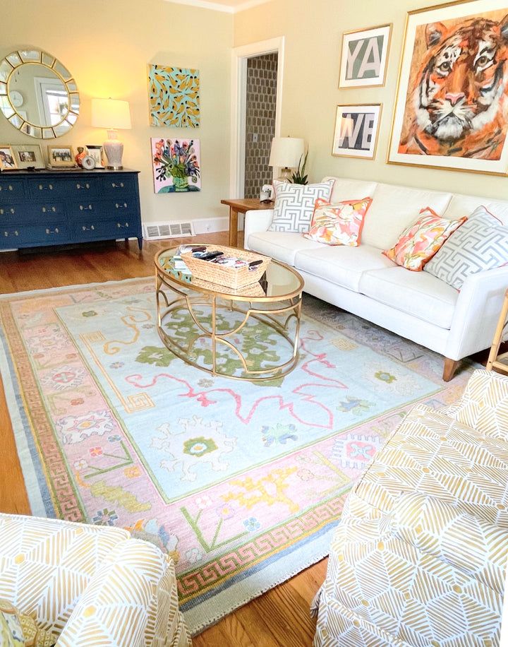 a living room filled with furniture and pictures on the wall above it's coffee table