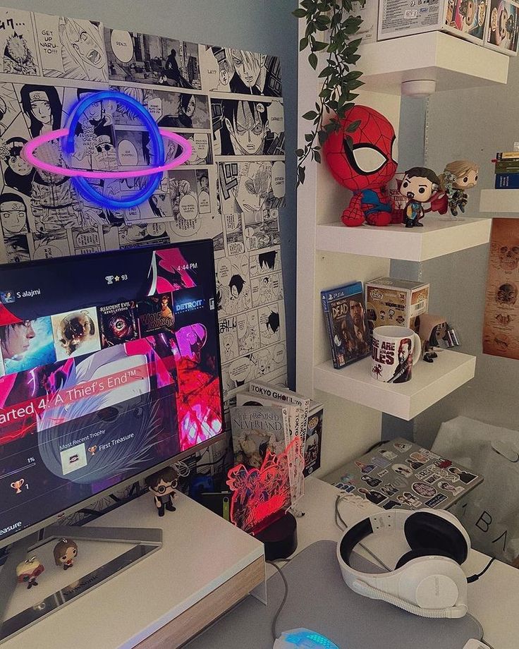 a desk with a monitor, keyboard and headphones on it