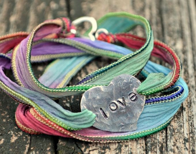 a bracelet with the word love written on it and a heart charm attached to it