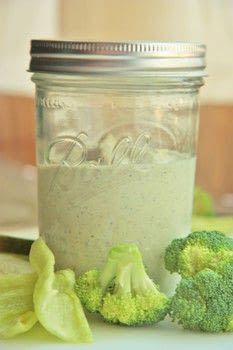 a jar filled with dressing next to broccoli