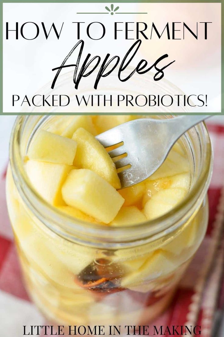 a mason jar filled with sliced apples on top of a red and white checkered table cloth