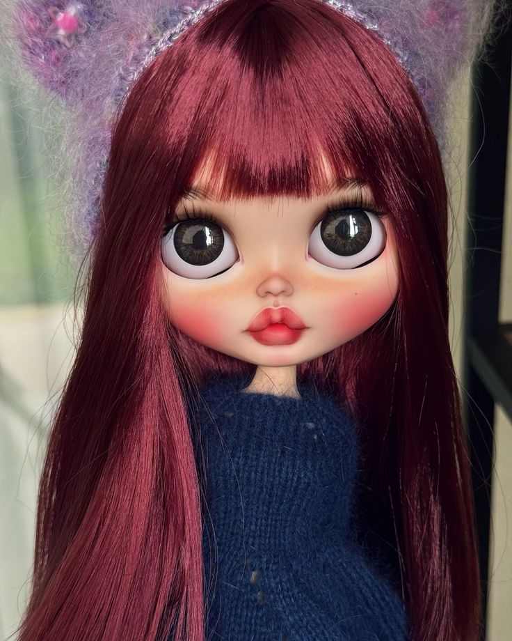 a close up of a doll with long red hair