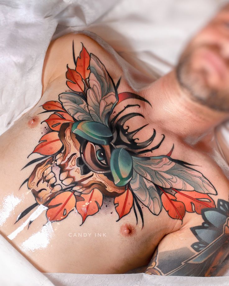 a man laying on top of a bed covered in lots of tattoos next to his stomach