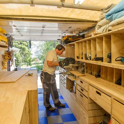 a man working in a garage with lots of shelves