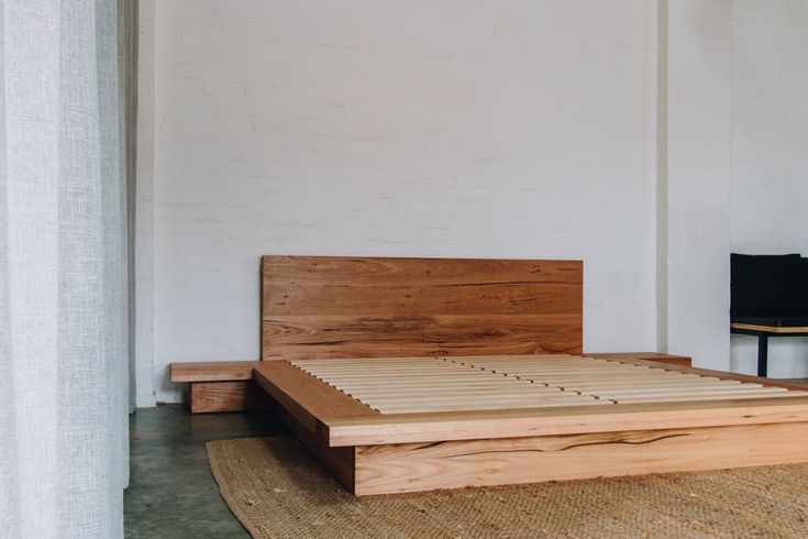 a wooden bed frame sitting on top of a rug