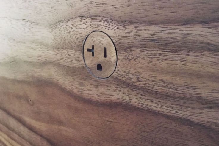 an electrical outlet on a wooden surface