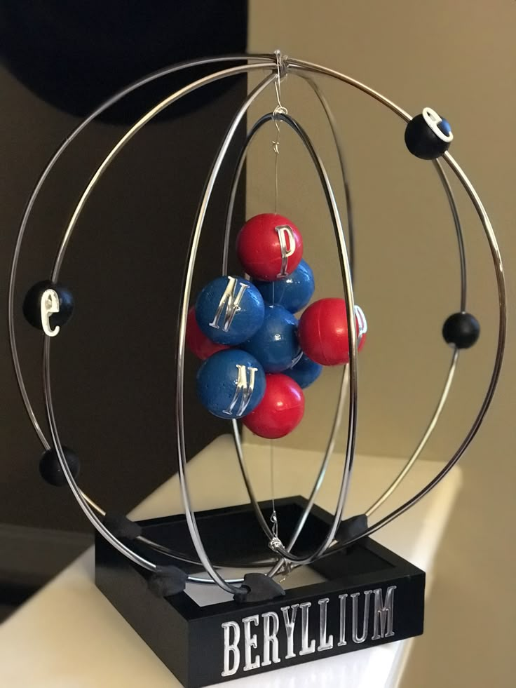 a metal sculpture with red, white and blue balls in it's centerpiece