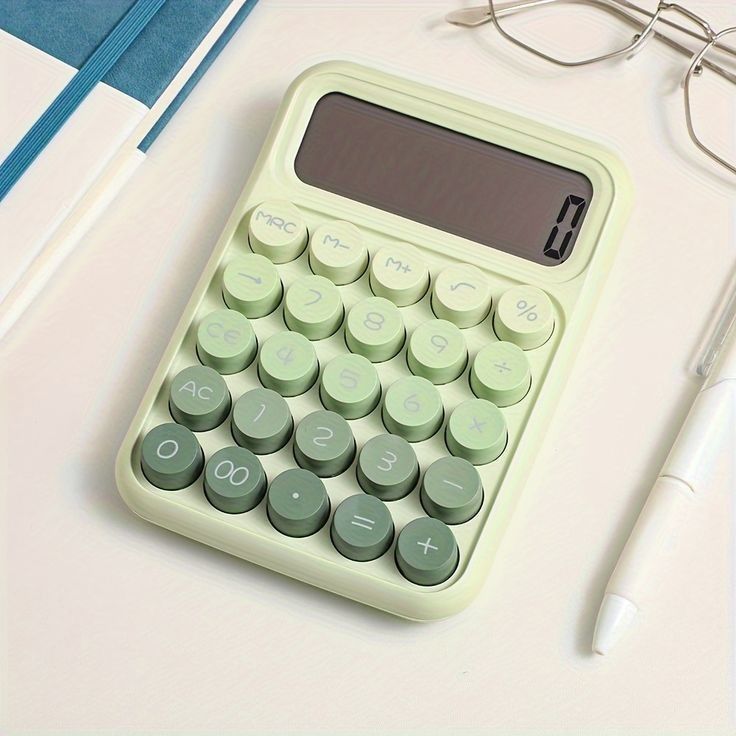 a calculator sitting on top of a white table next to eyeglasses