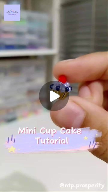 a person holding a tiny cupcake with blueberries on it's top and the words mini cup cake in front of them