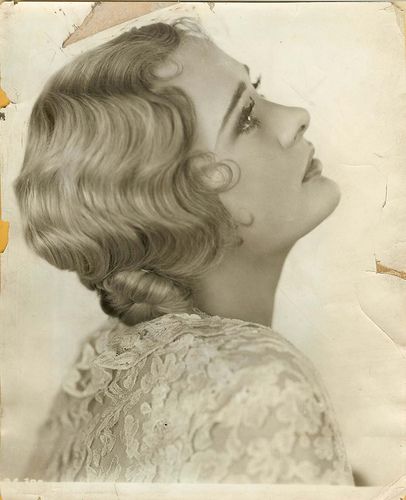 an old black and white photo of a woman's head with her eyes closed