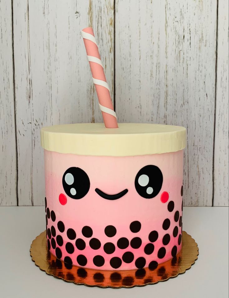 a cake with a pink frosting and black polka dots on it has a candle in the middle