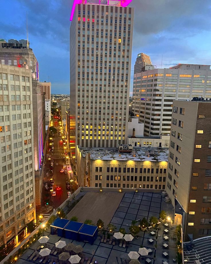 an aerial view of the city at night with umbrellas and buildings in the background