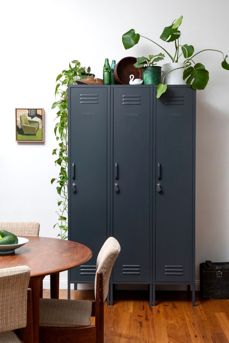 two metal lockers are next to a wooden table