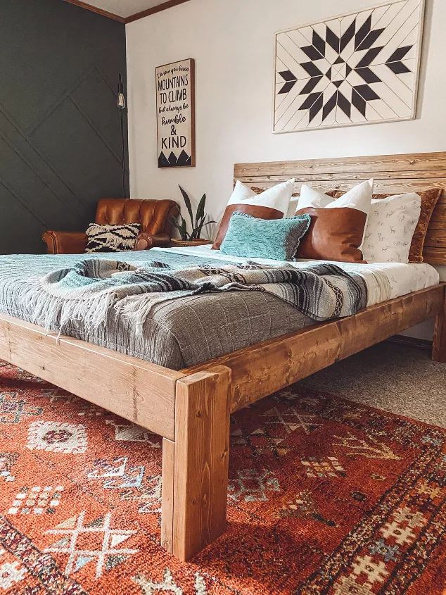 a large bed sitting on top of a red rug next to a wooden headboard