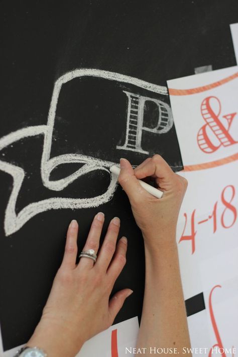 a person writing on a blackboard with white chalk