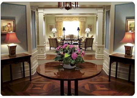 a living room filled with lots of furniture and flowers on top of a wooden table