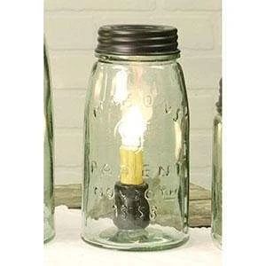 a mason jar with a lit candle in it