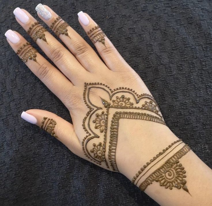 a woman's hand with henna tattoos on it