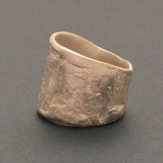 a silver ring sitting on top of a gray table next to a black countertop