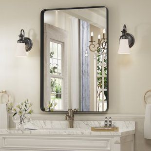 a bathroom with a fireplace and mirror on the wall