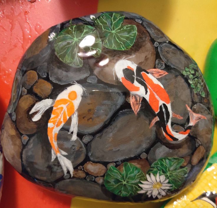 two koi fish are swimming in the pond on rocks and water lilies, surrounded by green leaves