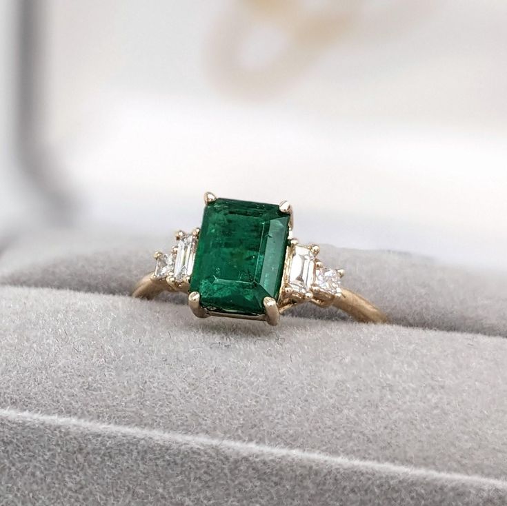 A vivid green emerald looks exquisite in this elegant minimalist ring with cute diamond accents. A statement ring design perfect for an eye catching engagement or anniversary. This ring also makes a beautiful May birthstone ring for your loved ones. This ring is made with solid 14K Gold and natural Earth mined SI / G-H diamonds. If you're interested in purchasing this setting with a different center stone please message us! Designer Silver Jewellery, May Birthstone Rings, Semi Mount Ring, Jewelry Showcases, May Birthstone, Minimalist Ring, Natural Earth, Green Emerald, Minimalist Rings