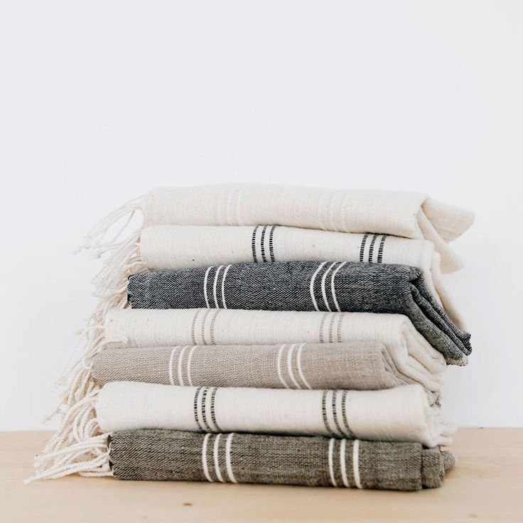 five towels stacked on top of each other in different colors and sizes, with one folded