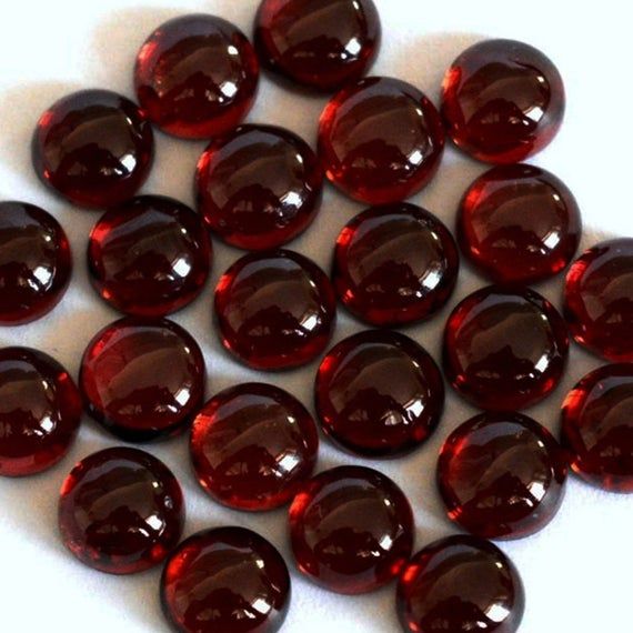 some red glass beads on a white surface