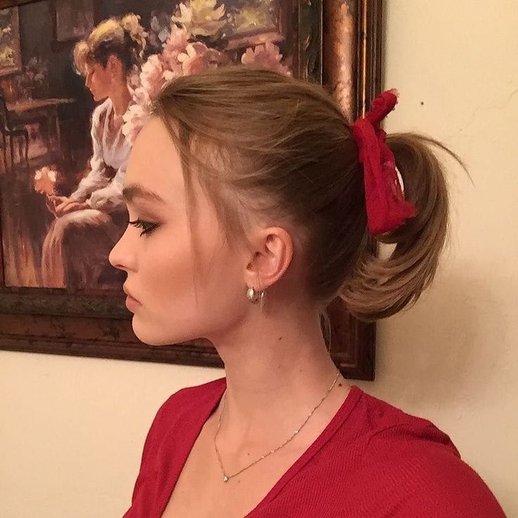 a woman with her hair in a high pony tail styled up into a low bun