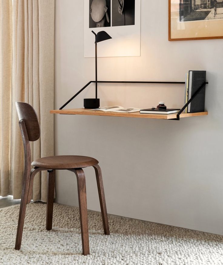 a wooden chair sitting in front of a desk with a lamp on top of it