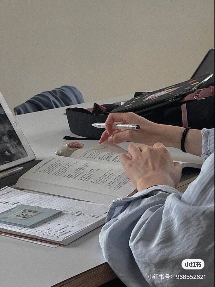 a person sitting at a desk with an open book