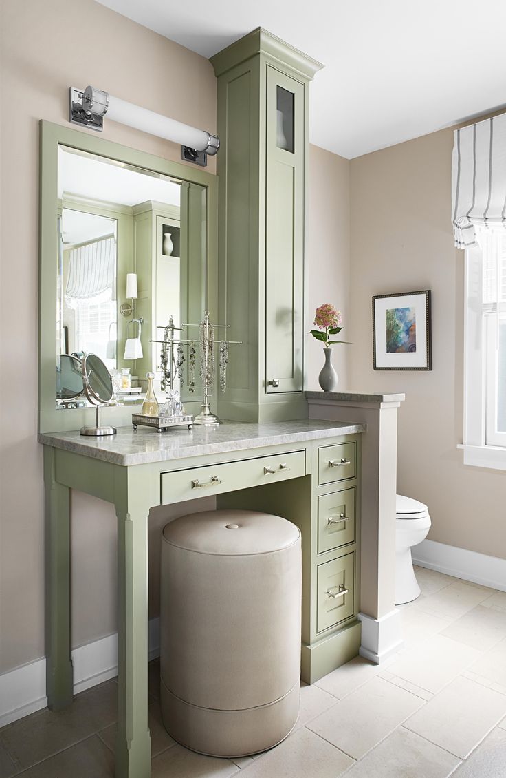 a bathroom with a vanity, toilet and window