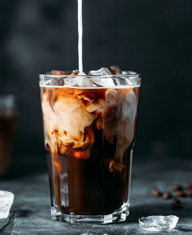 iced coffee with ice in a tall glass on a dark background, close up view