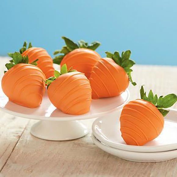 four pieces of chocolate covered strawberries on a white plate