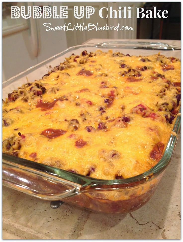 a casserole dish filled with meat and cheese in a glass baking dish on top of a counter