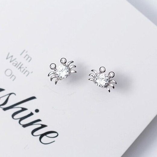 These cute crab stud earrings feature a big zirconia stone and two small zirconia stones on solid 925 sterling silver, highly polished for a great shine, with 18k gold plate or platinum plate to create the luxury look. Add these cute crab stud earrings to your everyday fine jewelry collection or as gift for your love one. Shipping Policy: Order will be shipped within 1-3 business days. First class mail will take 7-14 days to arrive for U.S. orders. International shipping time is vary per shippin Classic Sterling Silver Earrings With Diamond Eyes, Silver Plated Cubic Zirconia Diamond Earrings, Silver Cubic Zirconia Diamond Earrings With Plating, Silver Plated Diamond Earrings, Silver Earrings With Diamond Eyes Fine Jewelry, Silver Earrings With Diamond Eyes For Anniversary, Fine Jewelry Silver Earrings With Diamond Eyes, Luxurious Aesthetic, For Your Love