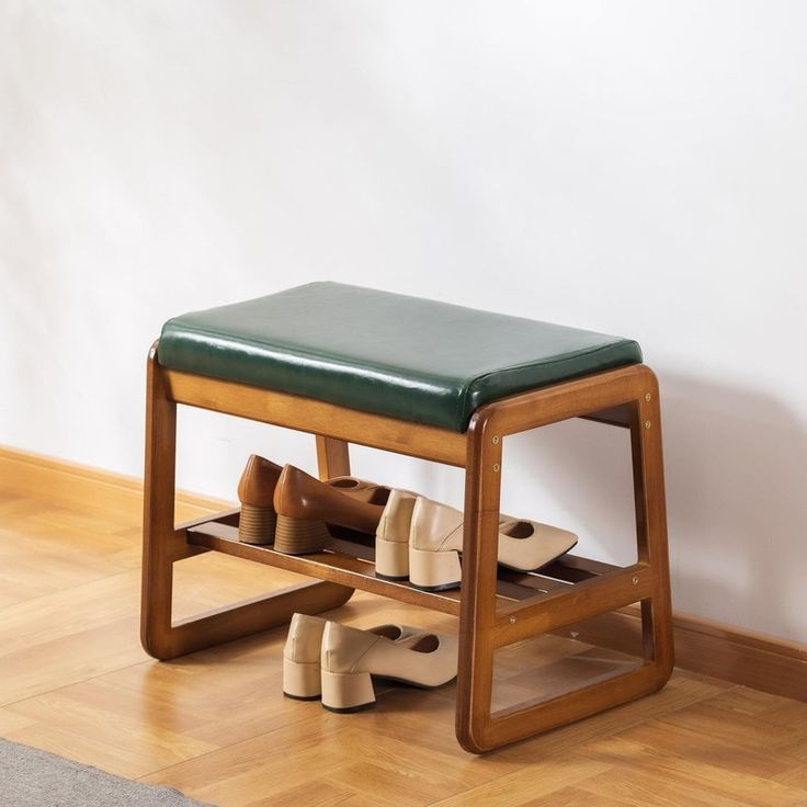 a wooden bench with shoes underneath it on the floor