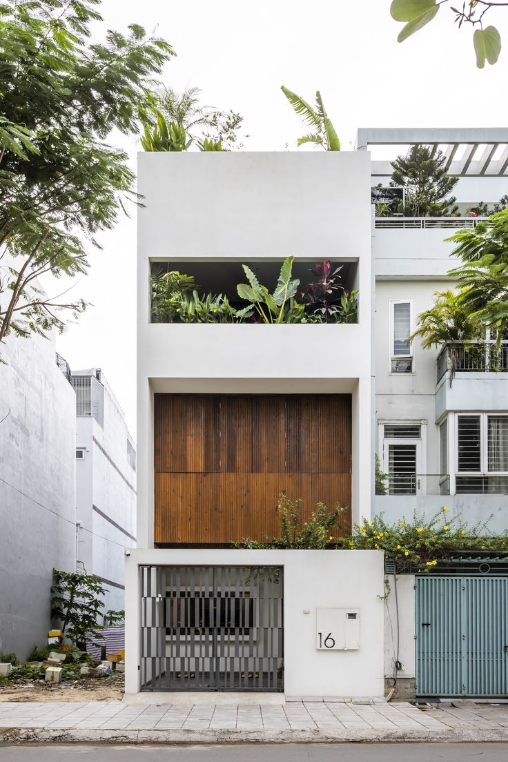 an apartment building with wooden doors and plants growing on the side of it's windows