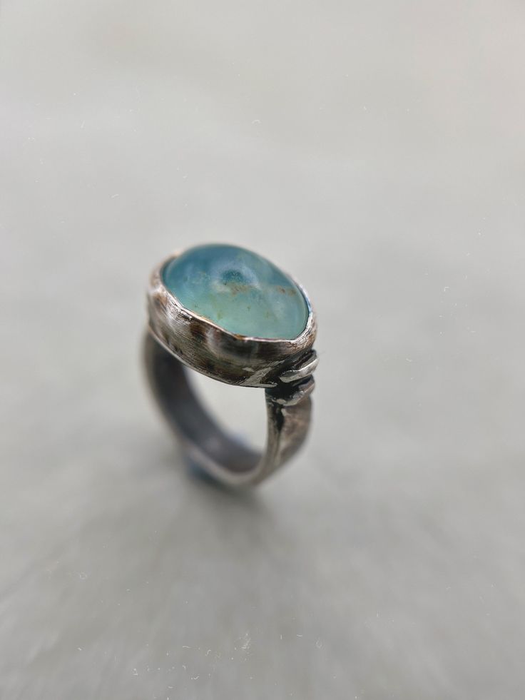 This listing is for a beautiful rare light aqua blue Andean Opal gem stone set into a chunky darkened sterling silver ring with a rustic finish for an earthy look. Opal is found and revered across the globe and can be found all over, from Canada to Ethiopia, Australia to Madagascar. But none are as rare and beautiful as the Andean Opals. These opals could only be found in Andean mountains in Peru.  Materials: Sterling silver 925 and fine silver 999, Andean blue Opal (Peru). Dimensions: Ring size