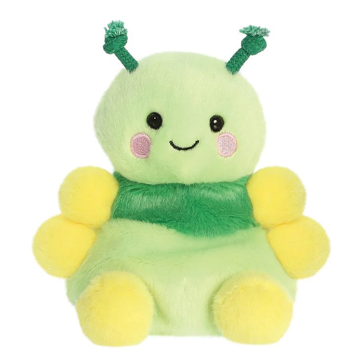 a green stuffed animal sitting on top of a white surface