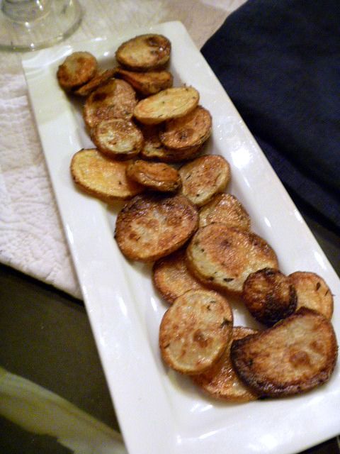 a white plate topped with fried potatoes on top of a table