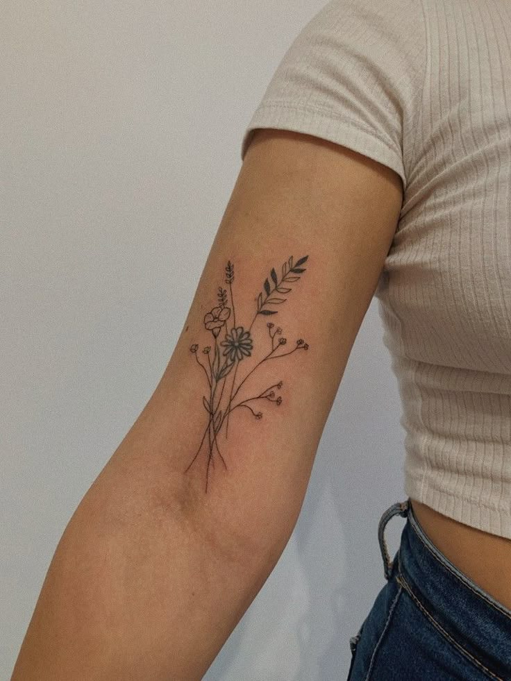 a woman's arm with a flower tattoo on the left side of her arm