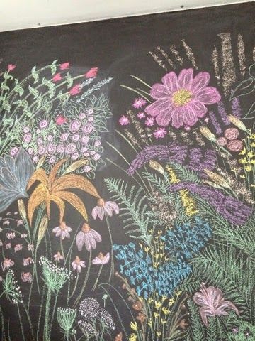 a chalkboard with flowers painted on it