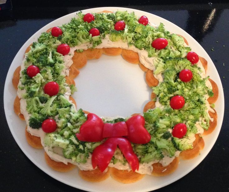 a white plate topped with a cake covered in broccoli and other toppings