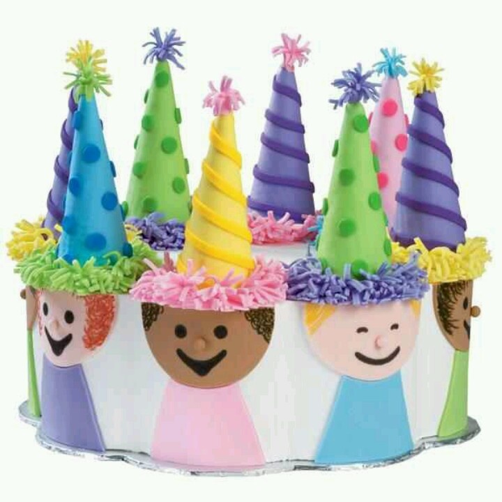 a group of children's birthday hats on top of a white cake covered in frosting